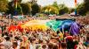 A crowd celebrating Pride 2017 in hull, carrying a large pride flag.
