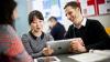 Two people using a tablet to help learn English