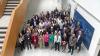 A large group of people stood in a bright foyer