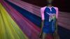 Model stood in front of pink, yellow and blue fabric.