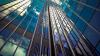 Glass skyscraper reflecting a blue sky with clouds