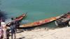 People at lakeside with small boats