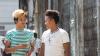 Two hip young adults in Myanmar walking down the street and talking to each other