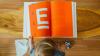 boy reading orange textbook