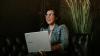 Woman sitting on sofa with a laptop 