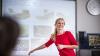 smiling woman in red dress in front of powerpoint presentation