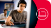 A young man uses a laptop while using headphones