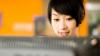 Chinese student looking at a computer screen and smiling