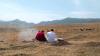 Two people sitting outdoors.