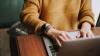 Woman working on a laptop and wearing a yellow jumper