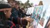 Community members look and point at photos at the exhibition of Photovoice club in Gia Lai province, Vietnam.
