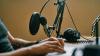 Person at a desk with a microphone and headphones