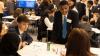 Young man presents his ideas to a table of fellow students