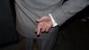 Image of man with fingers crossed behind back