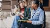 Two university students sitting on a step having a conversation