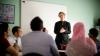 Adults in a classroom listening to a teacher