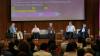 Panelists sitting on a stage at a conference.