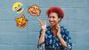 A teacher points and laughs at a cluster of emojis. 