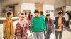 A group of young people walking together and chatting.