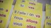A poster in a school - on a yellow background text says: Je vais. Tu vas. Il / elle / on va. Nous allons. Vous allez.