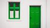Green door and windowframe on white house