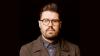 Man with dark moustache, beard and glasses.