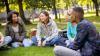 Young students sitting together outside in a park