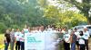 A group of people holding a banner outdoors.