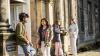 Group of students standing outside a building and chatting.