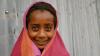 young girl smiling wearing pink headscarf
