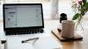 Laptop notebook and flowers on a desk facing a window