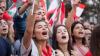 A group of young women in a local protest in Lebanon waving flags.
