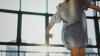 Woman dancing in striped dress in front of window