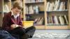 Young boy sits on the floor reading a book