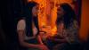 two teenage girls looking into each others eyes in a closet