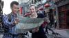 Woman and man on bikes in China studying a map and smiling