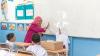 A teacher high fives her pupil in class.