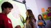 Teenage children using an interactive board in class.