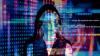 Woman with colourful computer coding reflected onto her