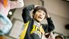 Young boy standing up with his hands on his head.