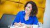 smiling woman looking up in blue shirt with yellow background