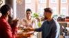 One woman and two men having a discussion over coffee