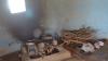 Photo shows a basic square hearth on the floor, with traditional pots and a bundle of twigs.