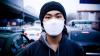 Man with pollution mask near traffic