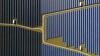 Aerial view of a large solar farm with rows of blue solar panels separated by dirt pathways.