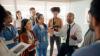 Students in a circle listening to a trainer talking to them and looking inspired