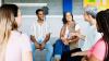 A group of adults sat in a circle having a conversation