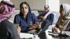 A businesswoman in hijab gesturing and explaining to colleagues at work.