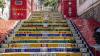 The view from the bottom of some colourful stairs with red tiled paths on either side.