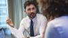 a man with a tie speaking with a woman